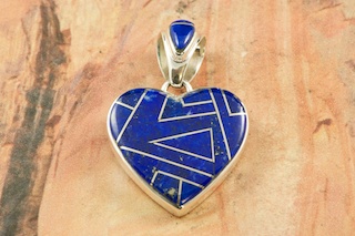 Genuine Blue Lapis inlaid between ribbons of Sterling Silver.  Free 18" Sterling Silver Chain with Purchase of Pendant. Pendant Designed by Navajo Artist Calvin Begay. Signed